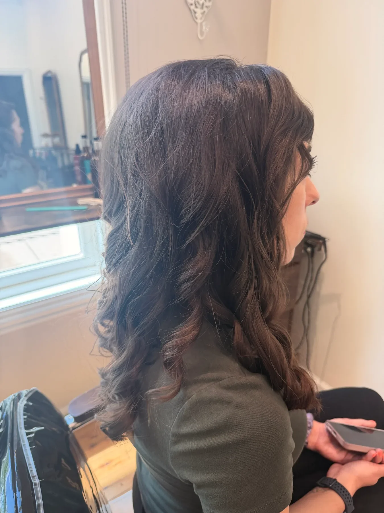 Glossy brunette hair styled in long waves by Glow Salon & Spa